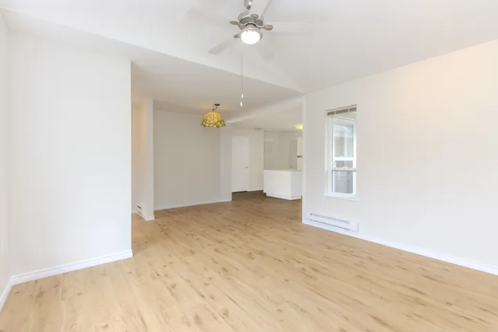 Unfurnished room with light wood-style floors, a baseboard radiator, and a ceiling fan