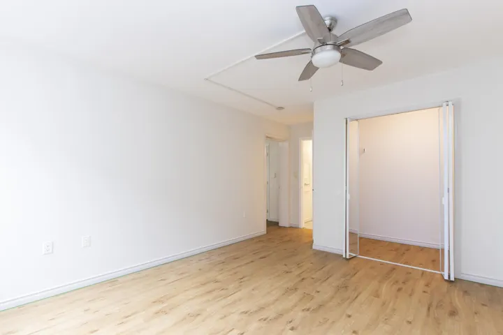 Unfurnished bedroom with light wood-type flooring, a closet, and a ceiling fan