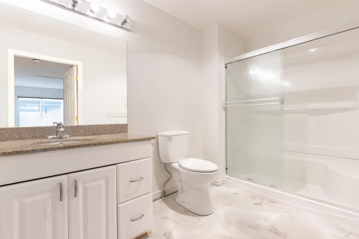 Full bath with vanity, a shower stall, and light marble finish flooring