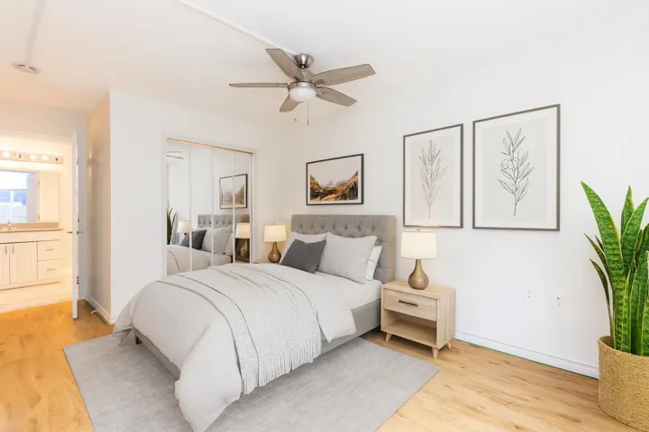 Bedroom with light wood-style floors, ceiling fan, a closet, and ensuite bath