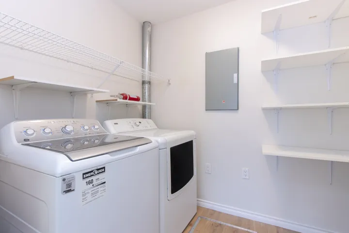 Laundry room with light wood finished floors and independent washer and dryer