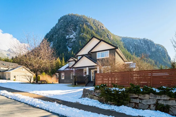 View of front of property with fence and a deck with mountain view