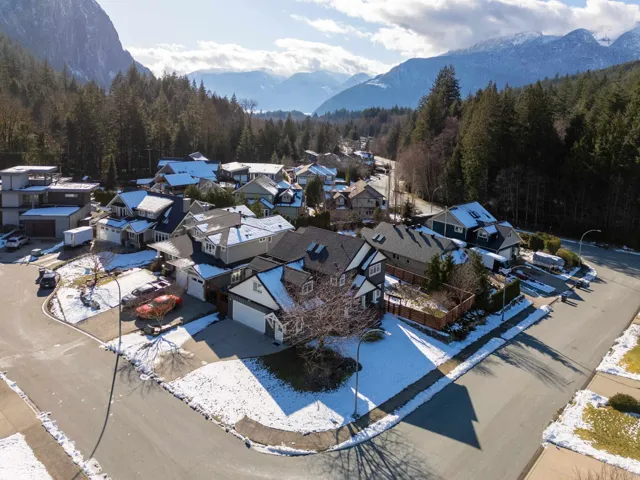 Aerial perspective of suburban area with a heavily wooded area and a mountain backdrop