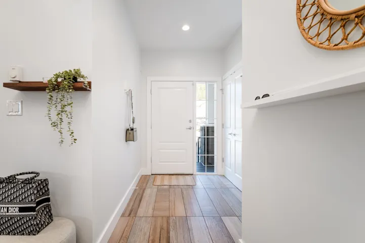 Doorway to outside with light wood finished floors, baseboards, and recessed lighting