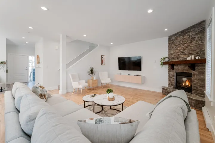 Living area featuring stairs, recessed lighting, a fireplace, wood finished floors, and baseboards