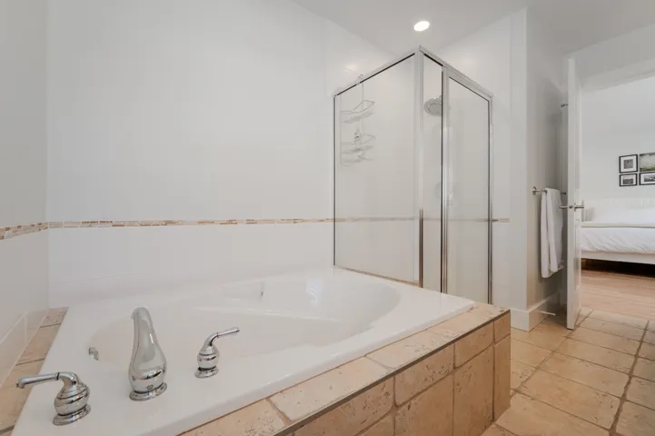 Ensuite bathroom featuring a stall shower, a garden tub, and recessed lighting