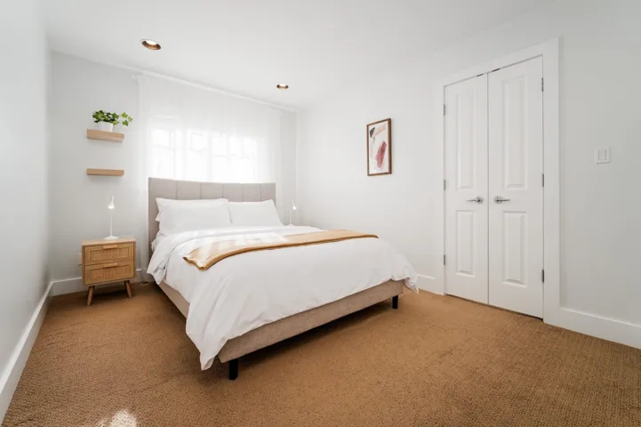 Bedroom with light colored carpet, baseboards, recessed lighting, and a closet