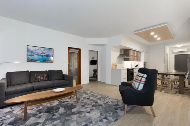 Living area with light wood finished floors and a wall unit AC