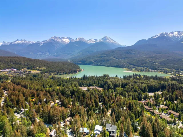 Mountain view featuring a nearby body of water and a forest