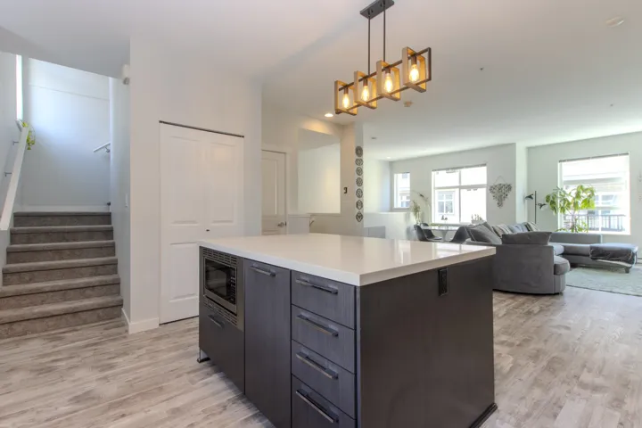 Kitchen featuring pendant lighting, a kitchen island, open floor plan, and light flooring