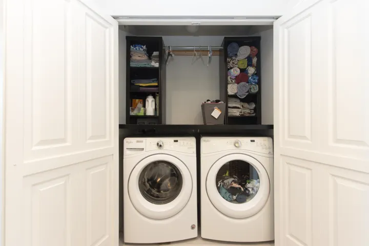 Laundry area featuring independent washer and dryer, storage and hanging above