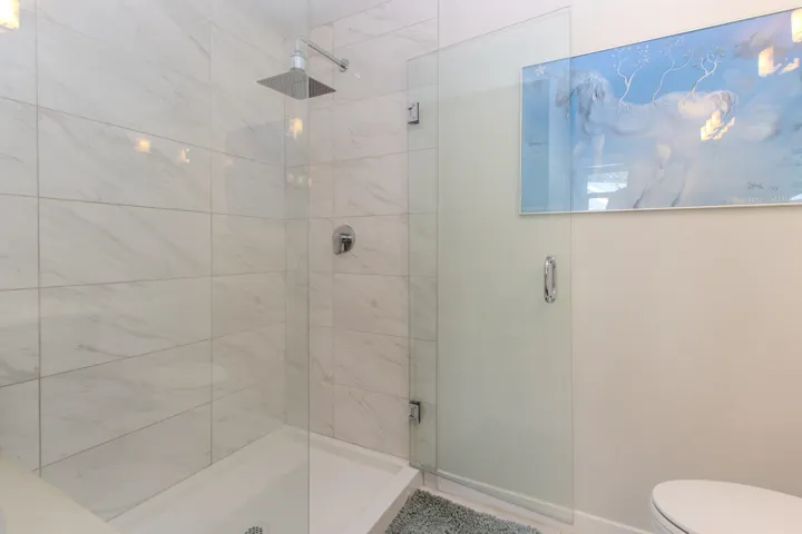 Oversized primary en-suite bathroom with vanity and large walk in shower.