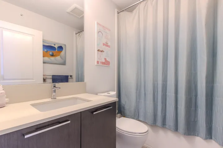 Full bath with tub/shower combination, toilet and large vanity
