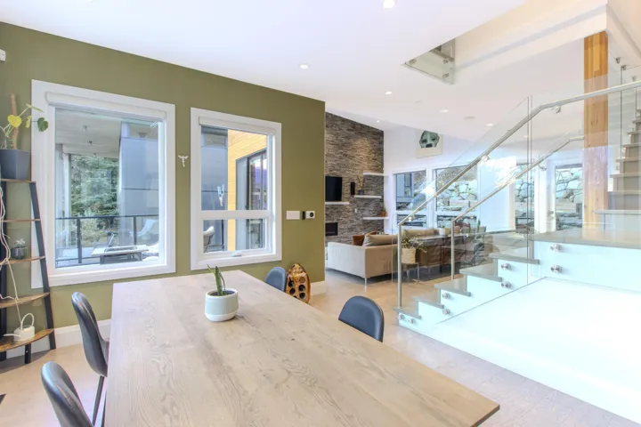 Dining room with stairway, a stone fireplace, and recessed lighting