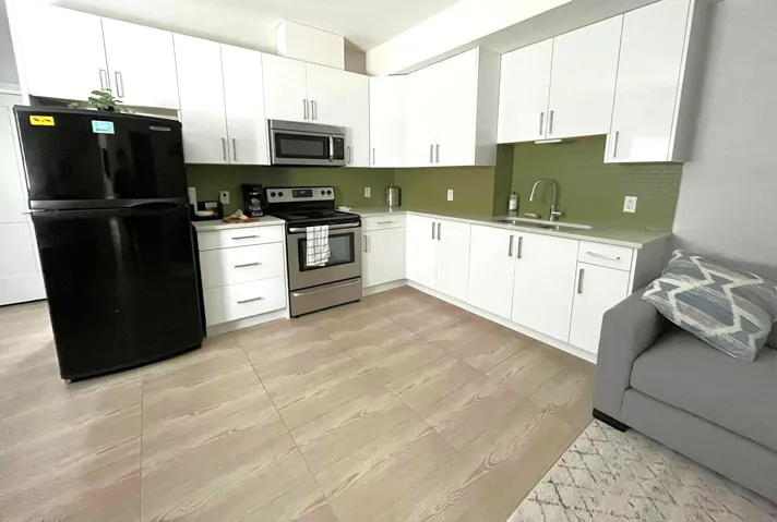 Kitchen featuring stainless steel appliances and white cabinetry