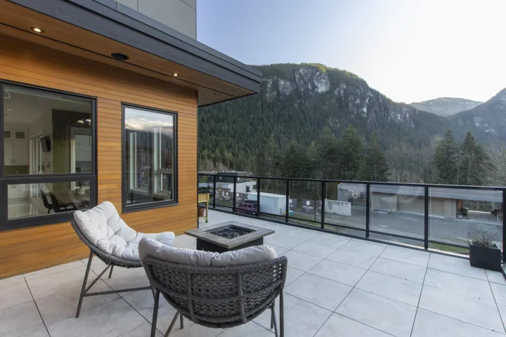View of patio with an outdoor fire pit, a mountain view, and a forest view