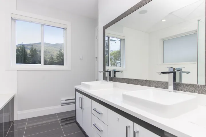 Bathroom with double vanity, a baseboard radiator, dark tile patterned flooring, and recessed lighting