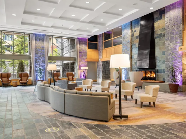 Building lobby with a towering ceiling, coffered ceiling, recessed lighting, and beam ceiling