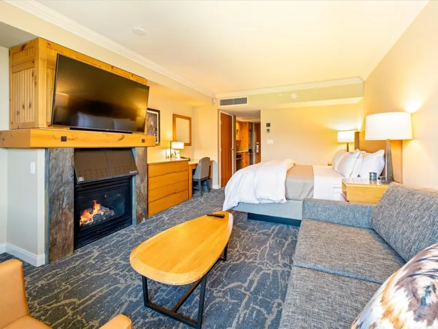 Carpeted bedroom featuring crown molding and a glass covered fireplace