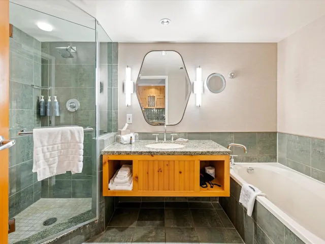 Bathroom featuring a stall shower, vanity, a garden tub, and tile patterned floors