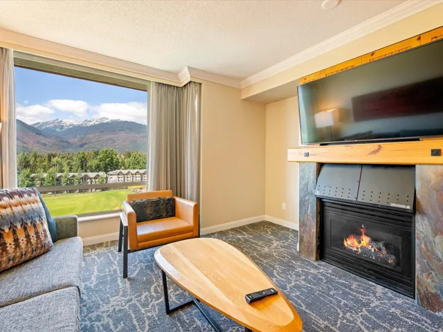 Carpeted living area featuring a fireplace, crown molding, and a textured ceiling