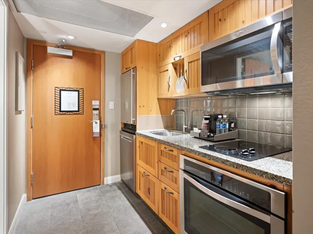 Kitchen with appliances with stainless steel finishes, light stone countertops, backsplash, and recessed lighting