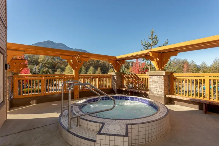 View of pool featuring a hot tub and a deck