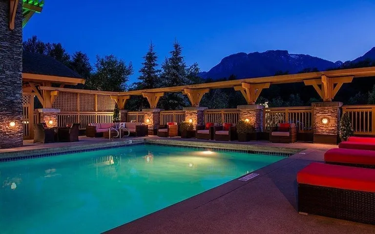 Pool at twilight with an outdoor living space, an outdoor pool, a mountain view, and a patio area