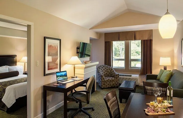 Living area featuring carpet, lofted ceiling, and a desk