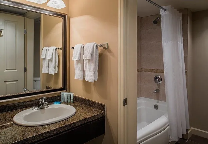 Full bathroom with shower / bath combination with curtain and vanity