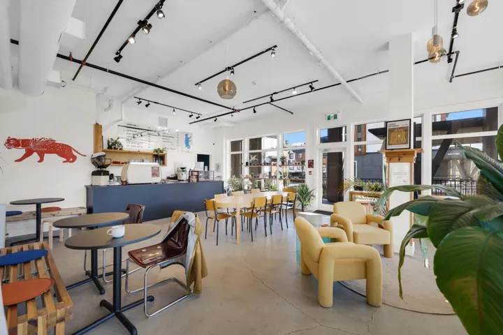 Expansive interior space featuring high ceilings with exposed ductwork and track lighting