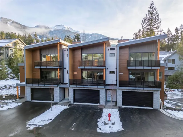 View of front of home with a mountain view, driveway, a garage, and a balcony