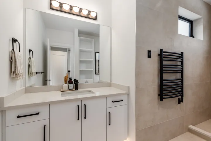 Full bathroom featuring radiator, vanity, and a towel warming rack