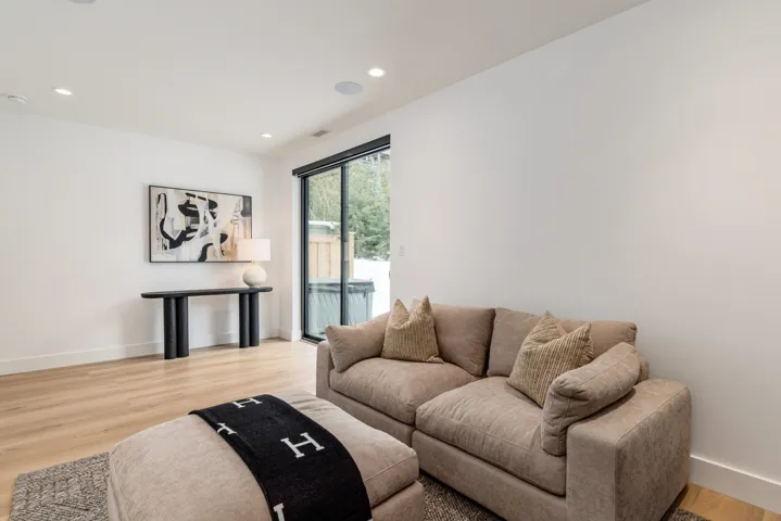 Living area with light wood-style floors and recessed lighting