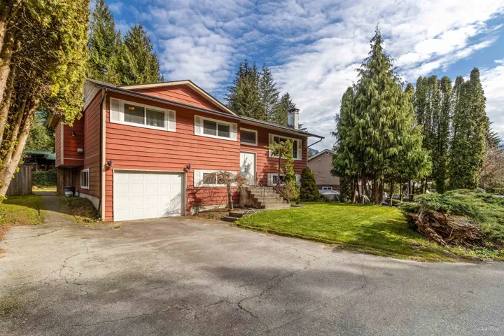 Bi-level home with a front yard, driveway, and a garage