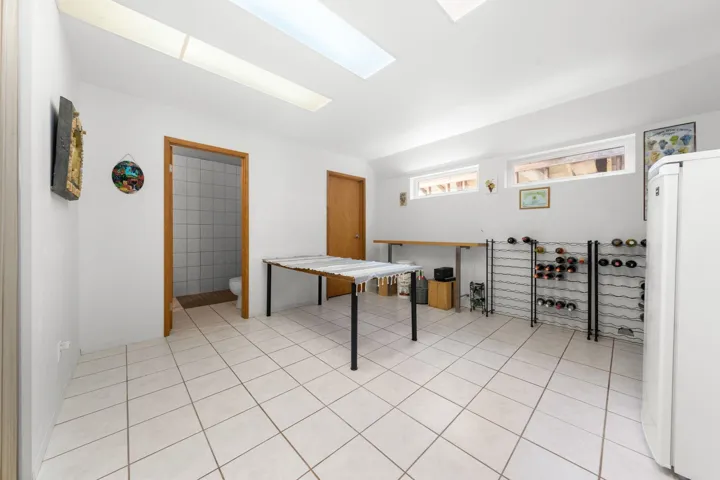 Bright room featuring tile flooring, two skylights, and multiple transom windows