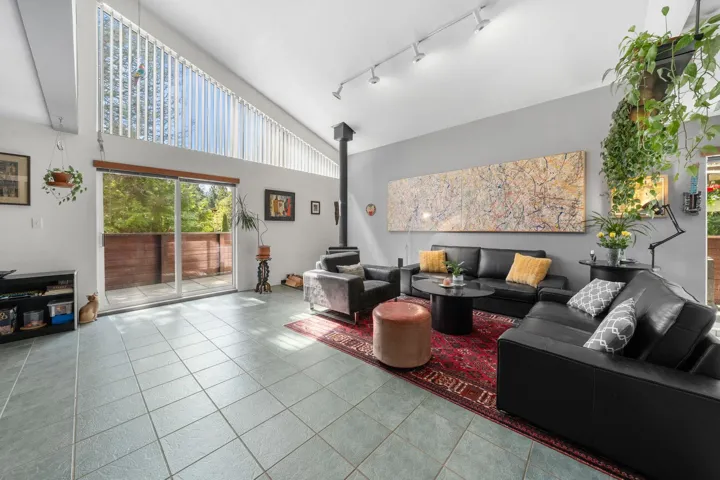 Vaulted ceiling with an upper transom window, tile flooring, and a floor-to-ceiling fireplace