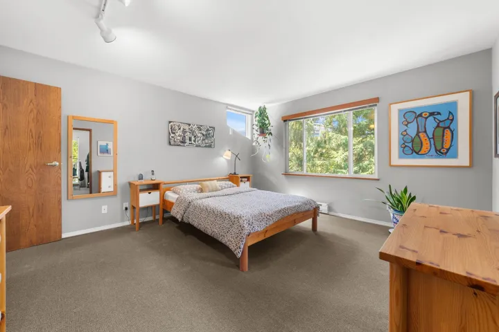 Spacious room featuring multiple windows, track lighting, and a solid wood door