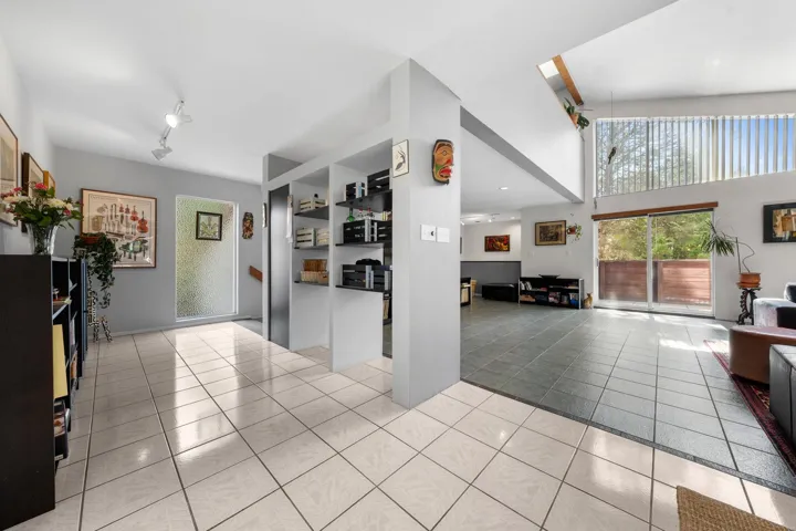 Entryway featuring white square tile flooring and built-in shelving