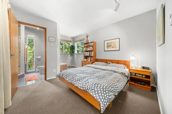 Carpeted room featuring light gray walls and multiple windows