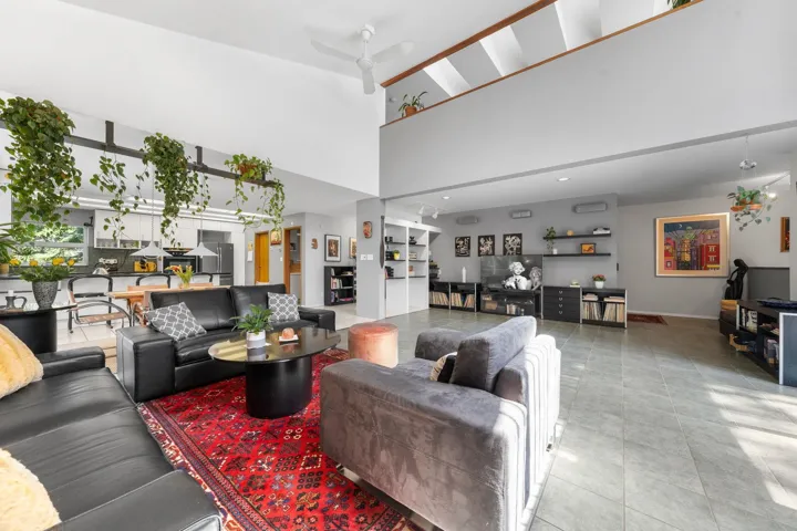 Expansive open-concept living area featuring a vaulted ceiling and an upper-level architectural detail