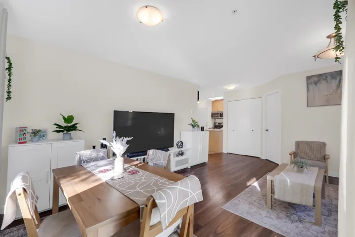 Open-concept interior featuring wood-finish flooring, neutral wall paint, and multiple flush-mount ceiling light fixtures