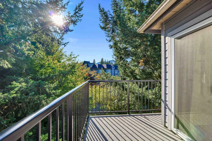 Exterior balcony with metal railing, composite-material decking, and sliding glass door