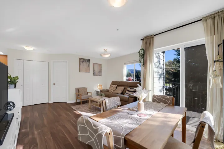 Open-concept interior featuring wood-finish flooring, dual-panel closet doors, and glass sliding doors providing external access