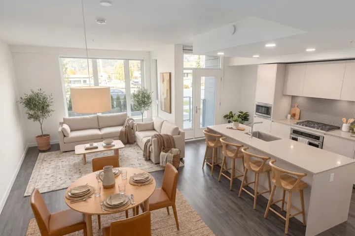 Open-concept living space featuring wood-finish flooring, recessed lighting, expansive windows, and a kitchen island with integrated sink