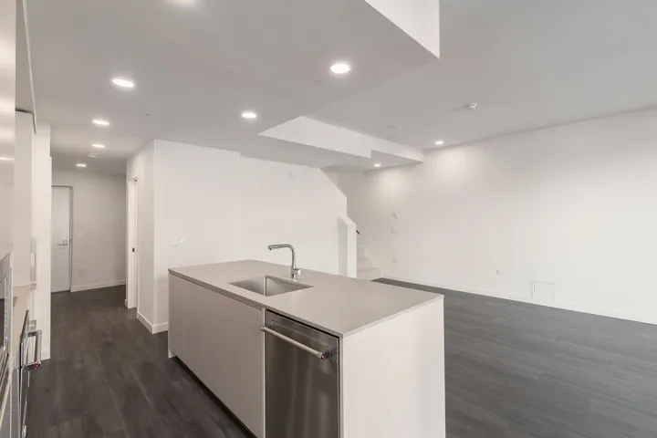 Modern kitchen island with an undermount sink, gooseneck faucet, and integrated dishwasher