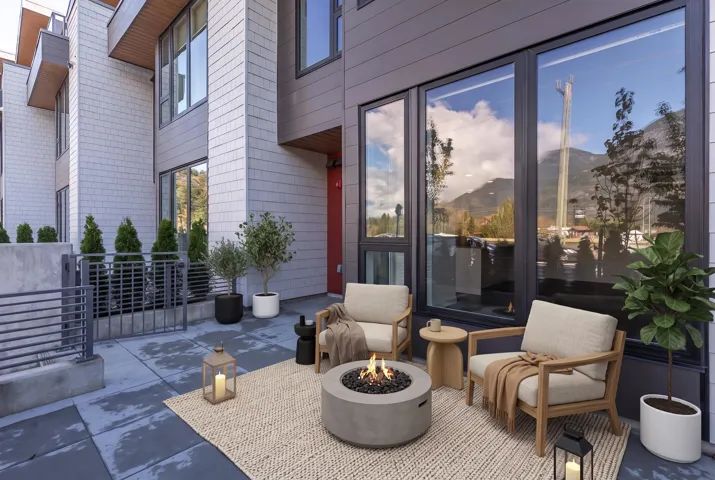 Outdoor patio with concrete pavers, a built-in fire pit, and large format windows