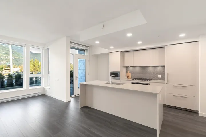 Kitchen featuring a gas range, integrated appliances, and a central island with an undermount sink