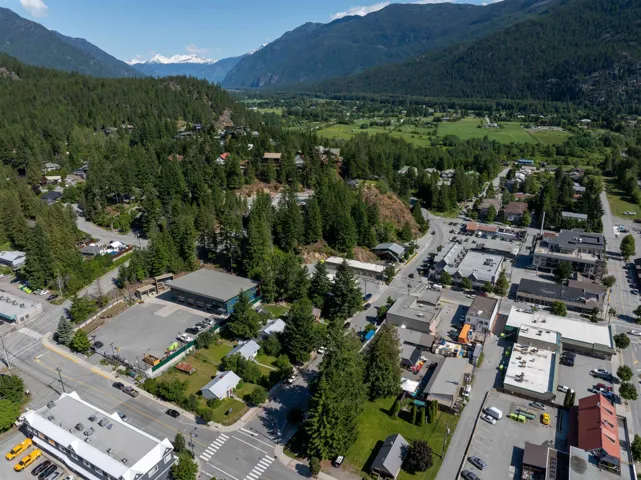 Aerial view of property and surrounding area featuring a heavily wooded area and a mountain backdrop