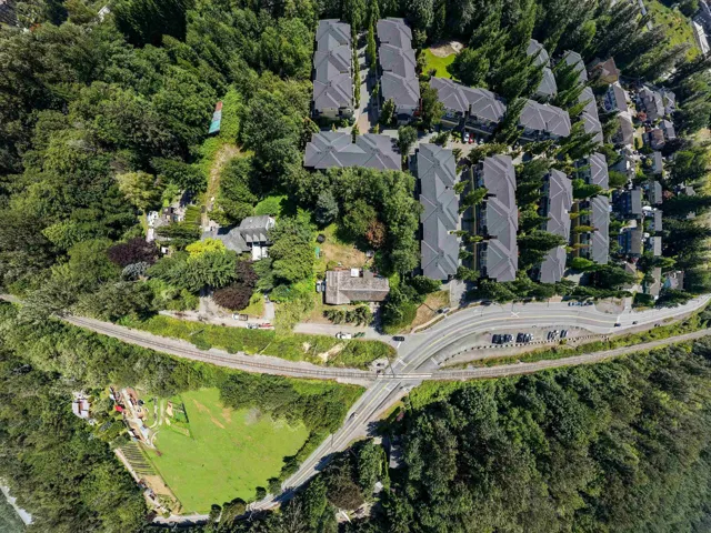 Aerial perspective showcasing a residential development nestled within a densely forested area